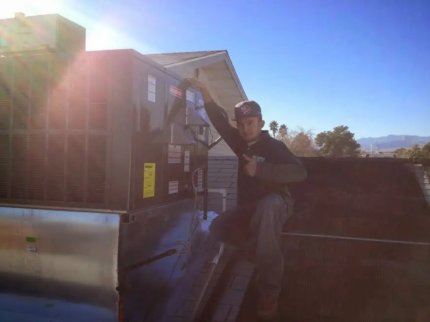 HVAC technician performing AC Tune-Up on a rooftop unit in Bushkill